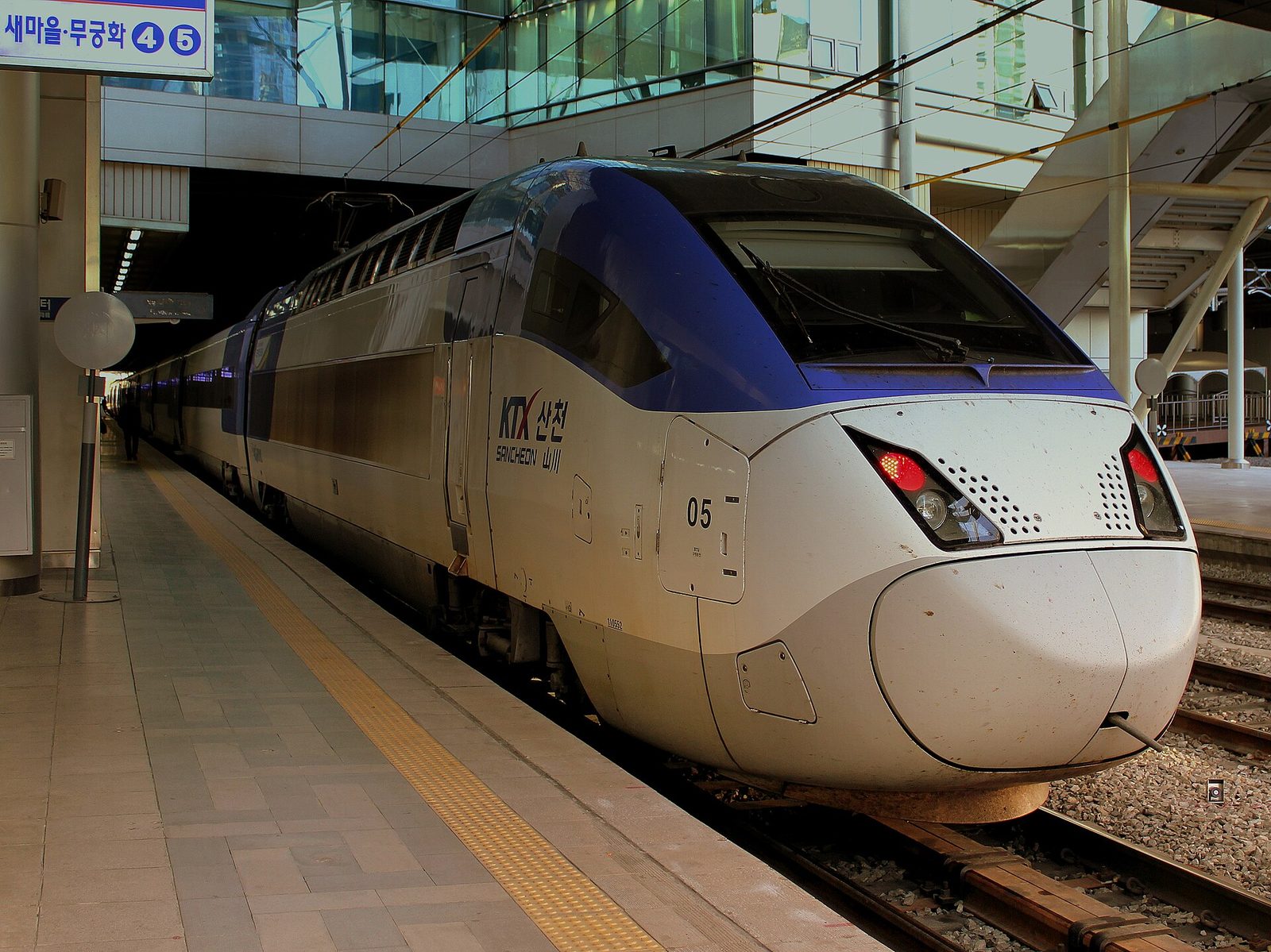 Passengers waiting beside a KTX train at a Korean railway station