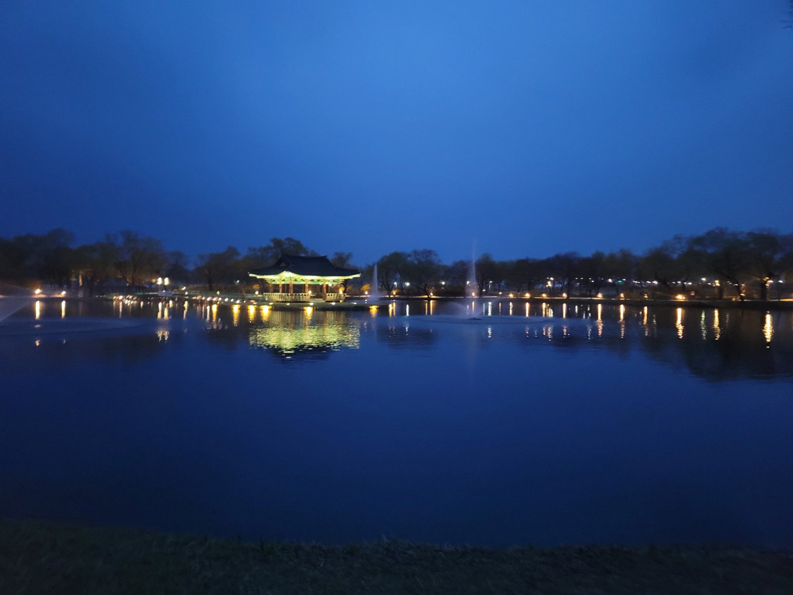 Poryongjeong pavilion reflected in Gungnamji pond on a blue spring evening