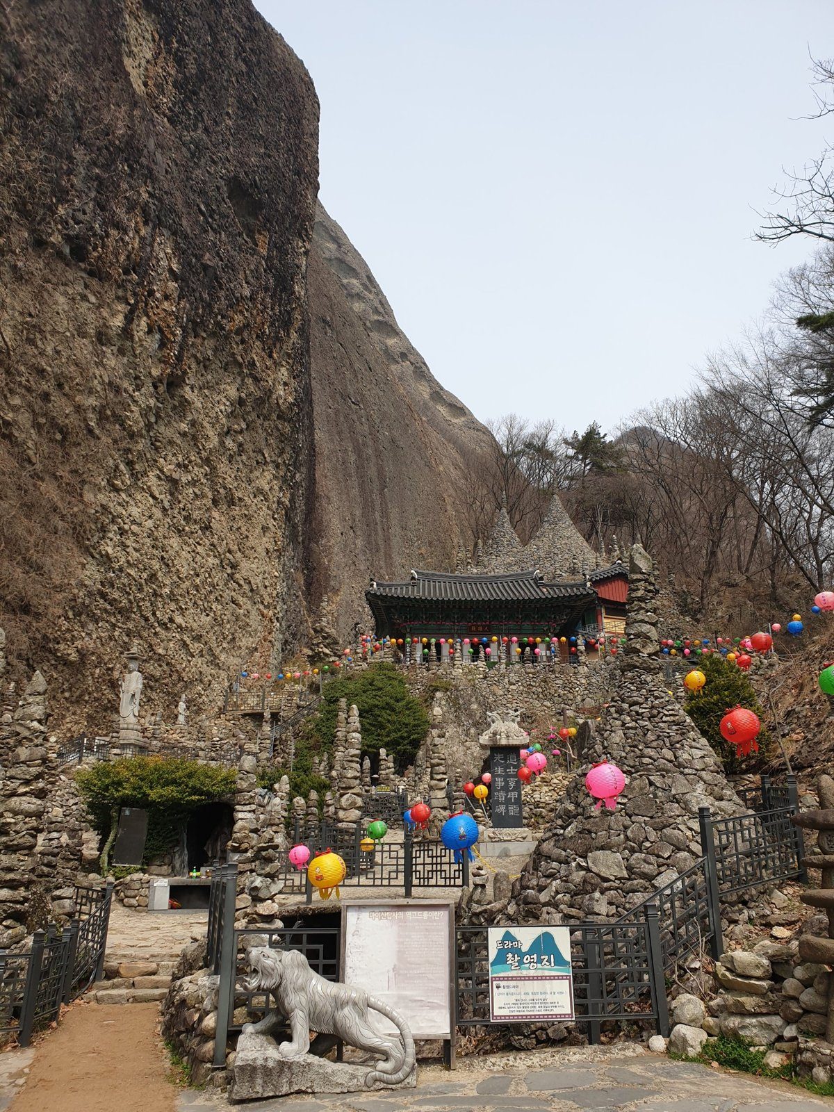 Tapsa temple hall, stone towers and paper lanterns beneath the cliffs of Maisan