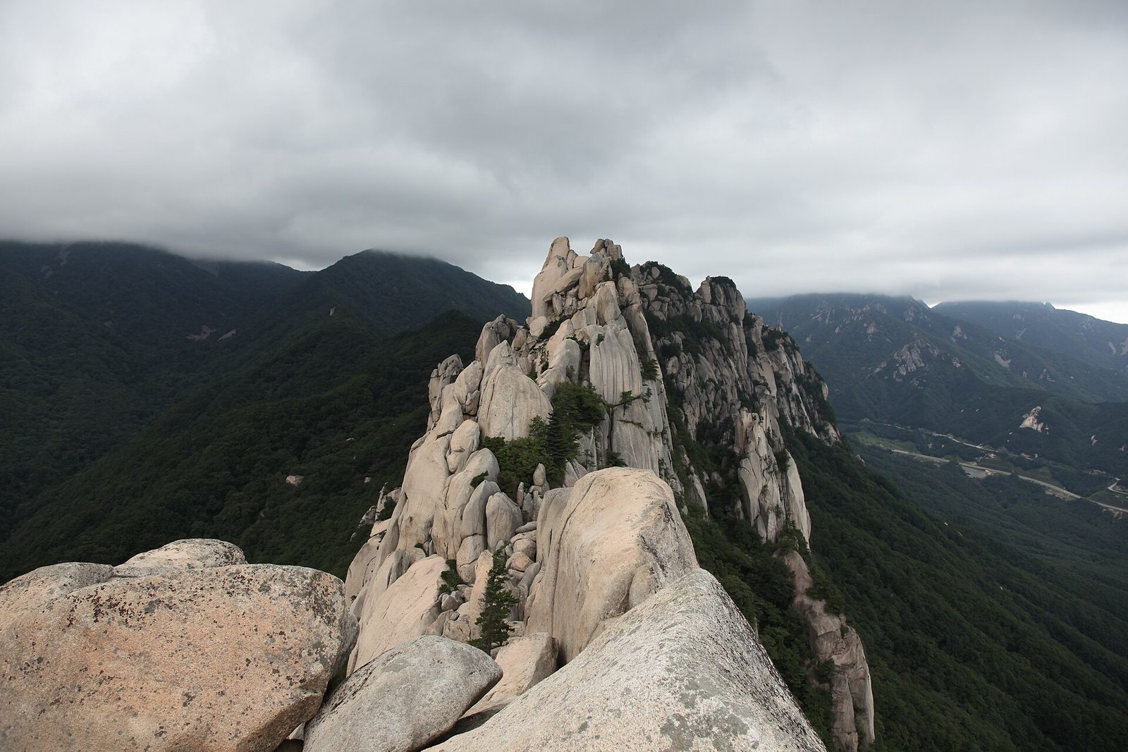 Hikers walking a mountain trail beneath the rocky peaks of Seoraksan National Park